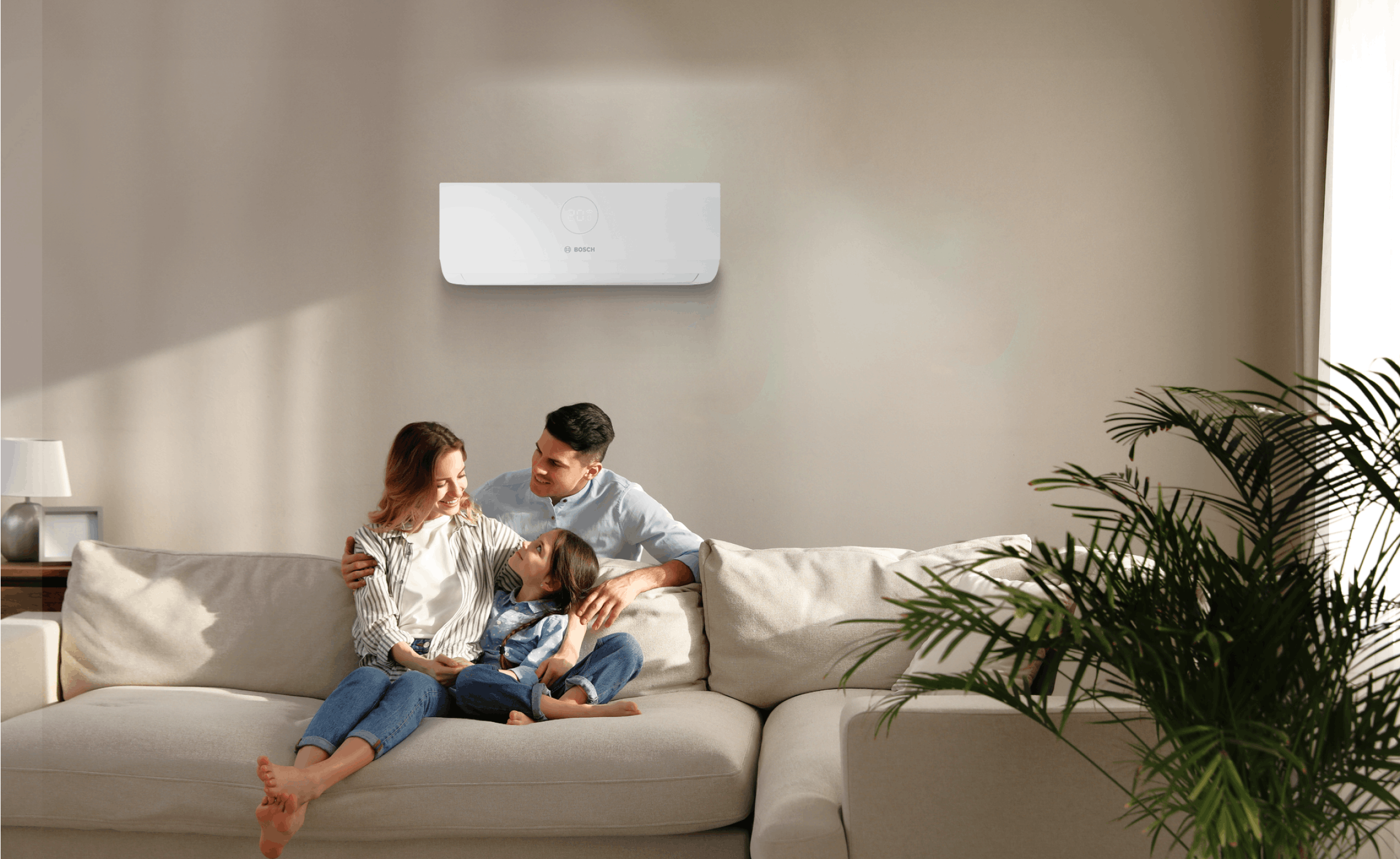 a family sitting on a sofa underneath an air conditioning unit