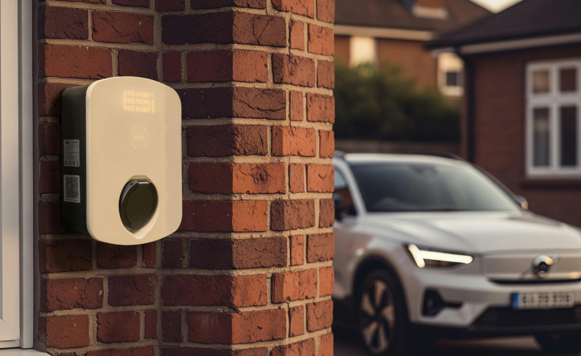 An ESi EV Charger with a car parked in the background
