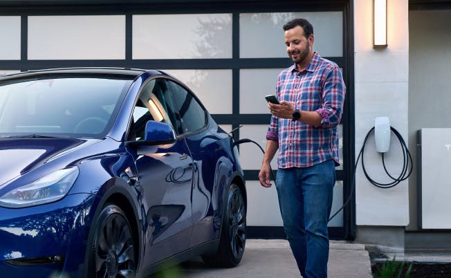 man charging and electric car with a wall mounted ev charger